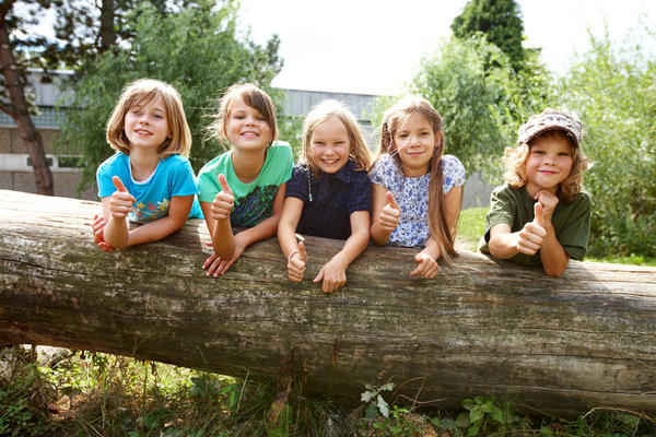 Kinder hinter Baumstamm